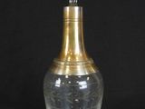 a glass bottle with a gold top on a black background