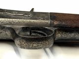an old gun with a wooden handle on a white surface