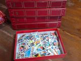 une boîte rouge remplie de timbres posée sur une table en bois