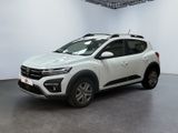 Une voiture blanche est garée dans une pièce blanche au sol noir.