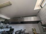 a kitchen with a stove and a range hood in it