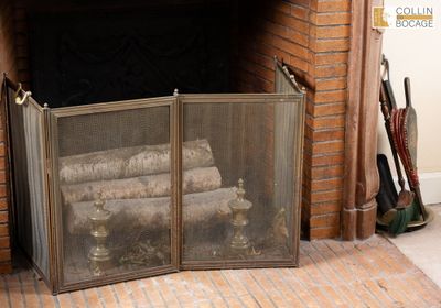 une cheminée avec un foyer et un tas de bûches à l'intérieur