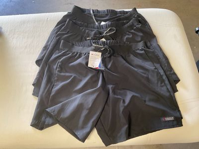 men ' s black swim shorts on a white couch in a room