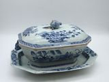 a blue and white dish with a bird on top of it