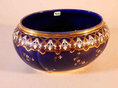un bol bleu orné de motifs dorés sur fond blanc