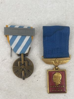 three medals are placed on a white surface with a blue ribbon