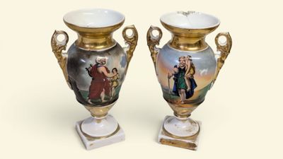 two vases with pictures on them sitting on a table