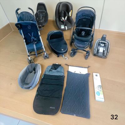 une poussette, un siège auto, un sac de couchage et un matelas de sol posés sur une table