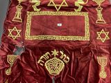 une nappe en velours rouge bordée d'or et ornée d'une étoile de David dorée