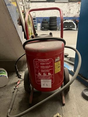 un extincteur rouge posé sur un chariot dans un garage