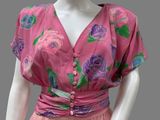 a mannequin wearing a pink dress with purple flowers on it