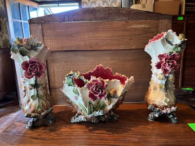 three vases that are sitting on a wooden table