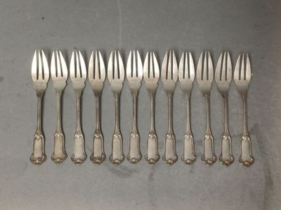 six fourchettes sont alignées en rang sur une table