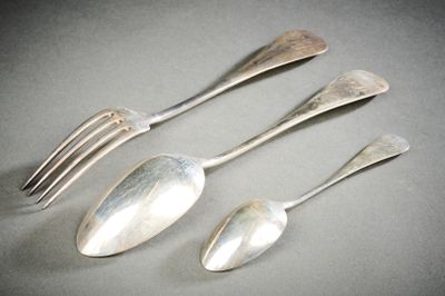 trois cuillères en argent et une fourchette sont posées sur une table