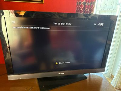 une télévision à écran plat posée sur une table en bois