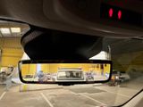 a rear view mirror of a car in a parking lot