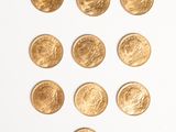 several gold coins are arranged in the shape of a heart on a white surface
