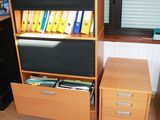 a desk with a file cabinet and a computer on it