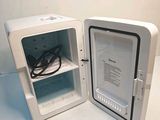 a small white refrigerator with an open door on the counter