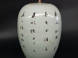 a white vase with black writing on it on a black background