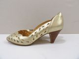 the woman ' s gold shoes are on a white surface