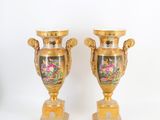 deux vases en or ornés de motifs floraux sur fond blanc