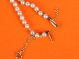 a close up of a white pearl necklace on an orange background