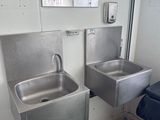 deux lavabos et une poubelle dans des toilettes publiques