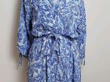 une robe bleue et blanche posée sur un présentoir pour mannequin