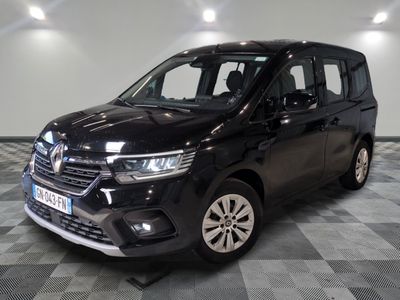 La camionnette noire est garée sur un sol à damier dans un garage.