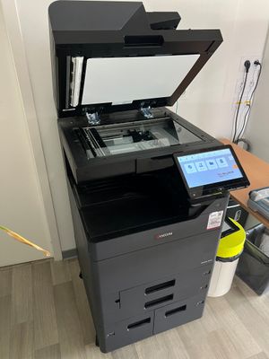 a printer sitting on top of a desk next to a laptop