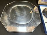 a silver plate sitting on top of a table next to a box