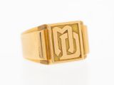 a close up of a gold signet ring with the letter g on it