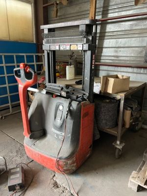 a forklift in a warehouse with boxes stacked on it