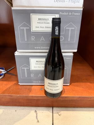 une bouteille de vin posée sur une étagère à côté de deux boîtes