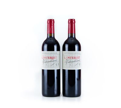 deux bouteilles de vin rouge posées l'une à côté de l'autre sur une surface blanche