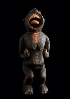 une statue en bois représentant un singe la bouche ouverte, sur fond noir