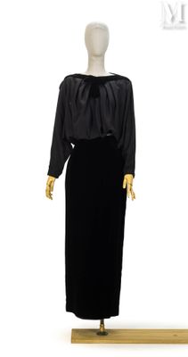 une photo d'un mannequin vêtu d'une robe noire, posé sur un socle en bois