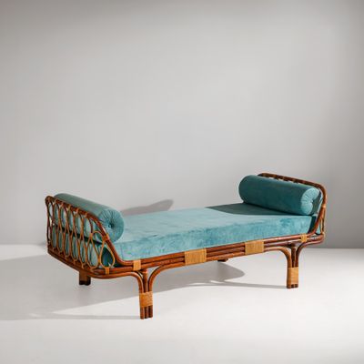 an upholstered rattan daybed with a blue cushion on it