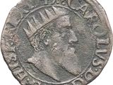 a silver coin with an image of a man wearing a crown