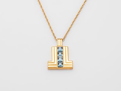 a gold necklace with a blue topaz stone in the center