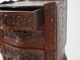 carved wooden chest of drawers on stand against a white background