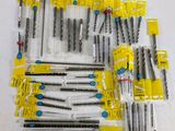 lot of assorted drill bits in plastic bags on a table