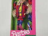 La poupée Barbie se trouve dans une boîte rose posée sur une surface blanche.