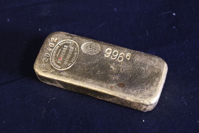 un lingot d'or posé sur un tissu bleu