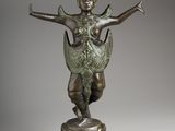 a bronze statue of a woman holding a bird on a pedestal