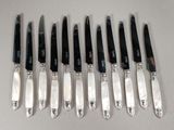six knives are lined up in a row on a table
