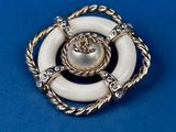 a close up of a white broochle with a rope around it