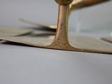 a close up of a gold candle holder on a table