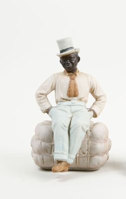 two figurines of a man and a woman sitting on a couch